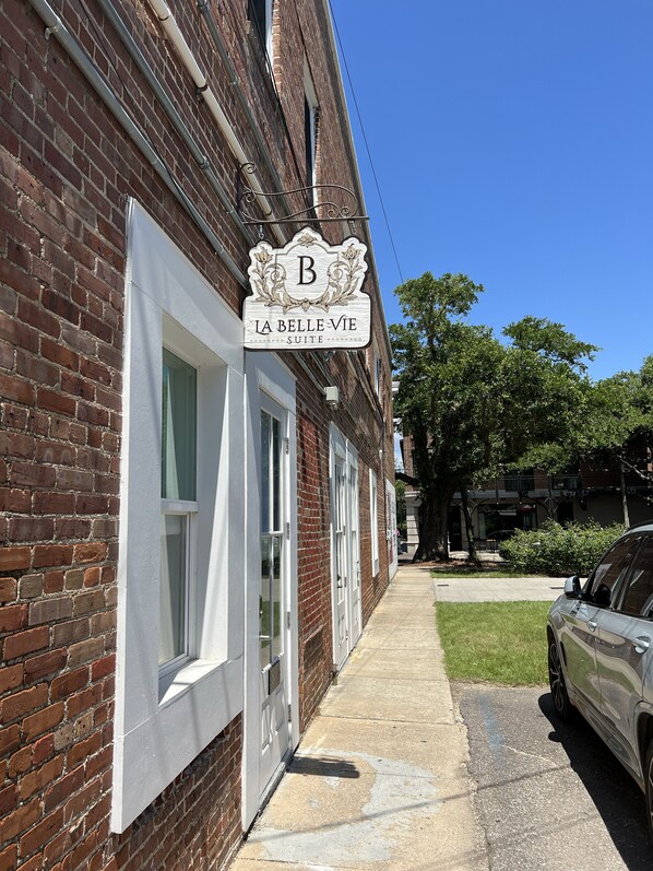 A brick building with a sign reading "La Belle Vie Suite". - King Size Suite located in Downtown Ocean Springs (Ocean Springs)