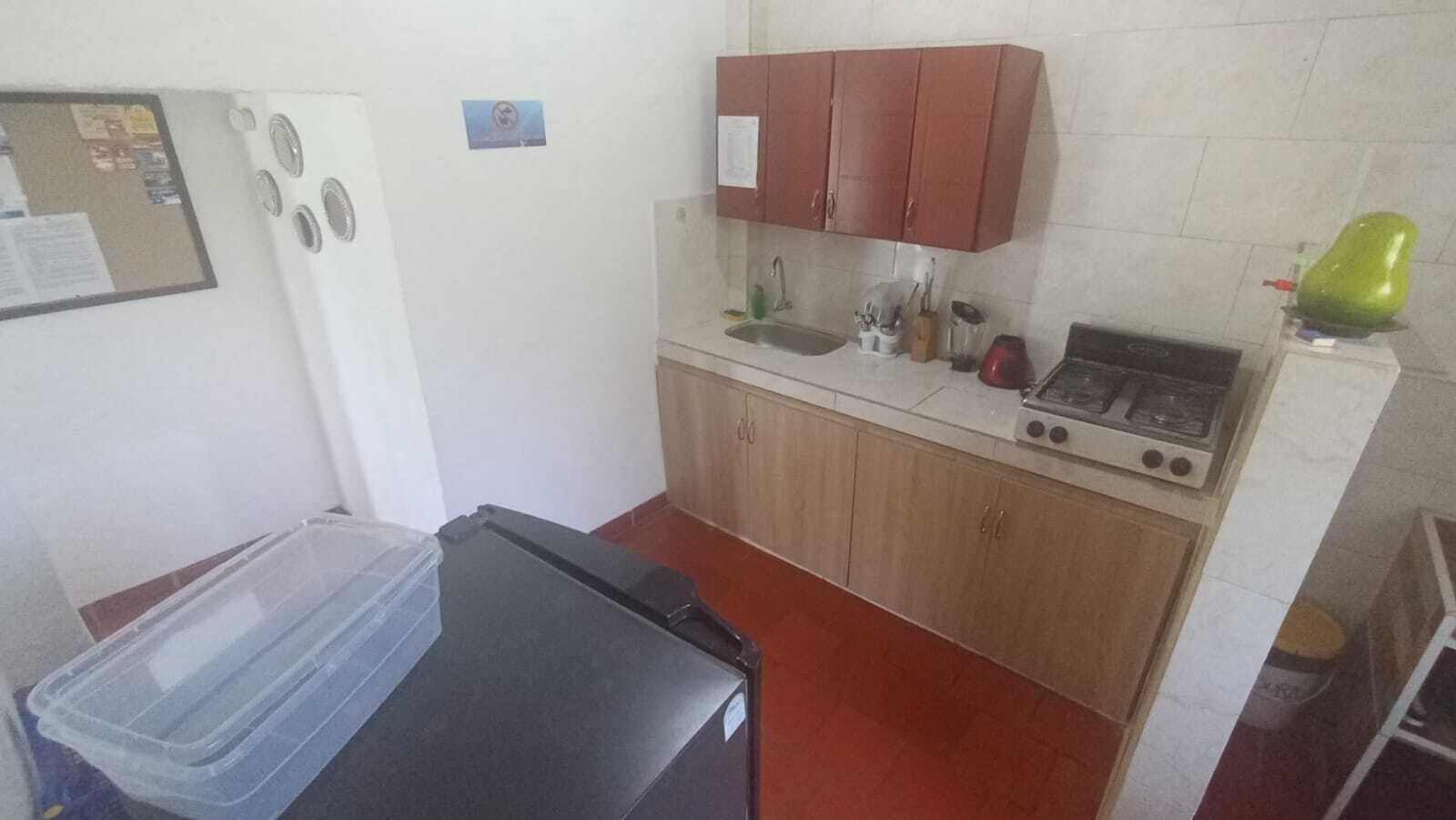 A compact kitchen with a stove, sink, and wooden cabinets.
