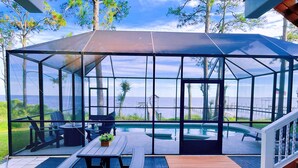 Et overdækket udendørs område med pool, picnicbord og siddepladser.