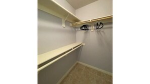A small, enclosed closet with two shelves and a hanging rod. - Lavender home: King & Queen (Edinburg)