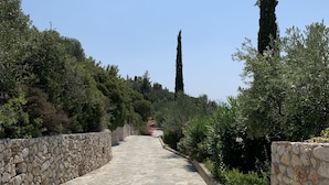 Ein gepflegter Garten mit Steinmauern und Grünflächen, durch den ein Kiesweg führt.