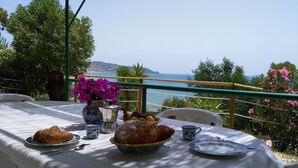 Une table dressée avec de la nourriture et des boissons, offrant une vue panoramique sur la côte.