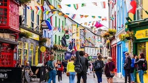 A bustling street with colorful buildings and flags.