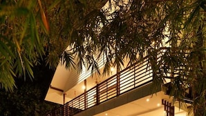 A two-story building with a balcony and a covered outdoor seating area. - Lhasa Ayurveda and Wellness Resort (North Paravur)