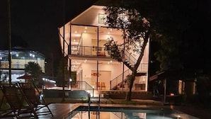 A swimming pool with a glass enclosure and a staircase leading to an upper level. - Lhasa Ayurveda and Wellness Resort (North Paravur)