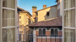 Una calle estrecha con edificios de arquitectura tradicional, incluyendo una torre de campanas visible y ventanas de arco.