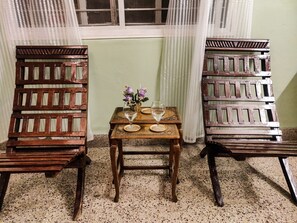 Relax in a serene space with a traditional design, featuring two chairs and a small table perfect for a quiet meal or moment of relaxation.