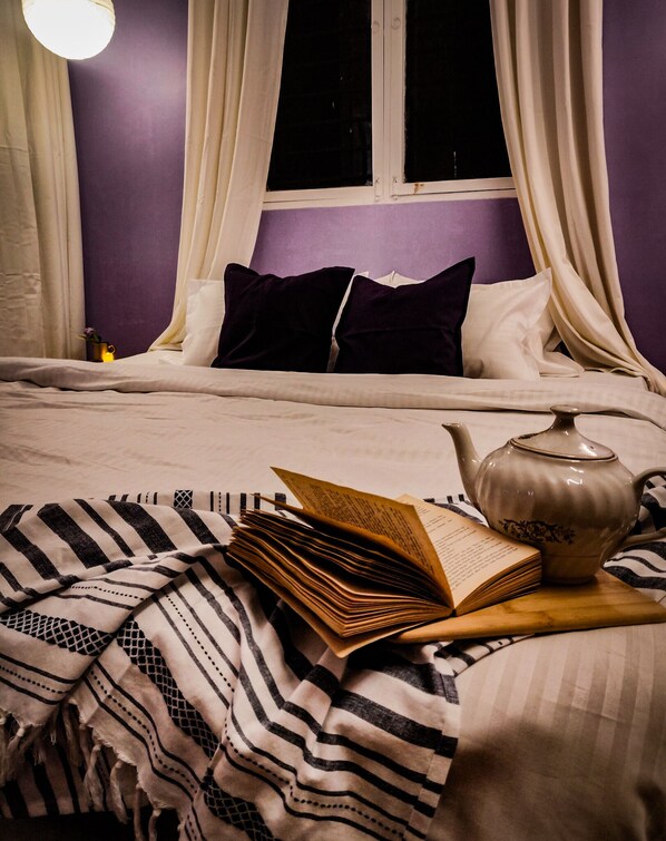 Relax in this inviting space with a comfortable bed, a book to read, and a teapot nearby.
