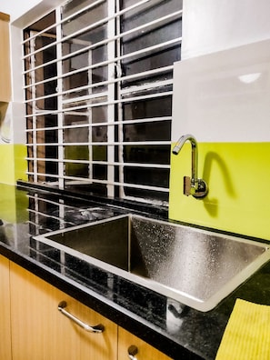 Sink, stove, and window in a well-equipped kitchen.
