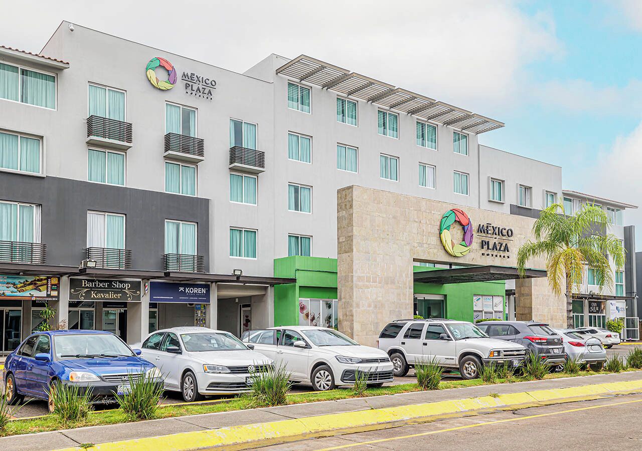 A multi-story hotel with a modern design, featuring a prominent 'Mexico Plaza' sign.