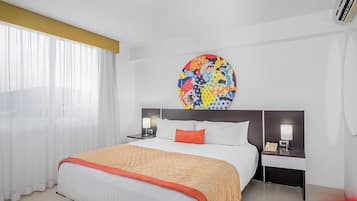 Een hotelkamer met een bed, twee nachtkastjes, een groot rond schilderij en een bord met 'BLACK FRIDAY'.