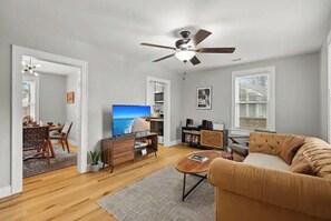 Relax in this inviting living room with a sofa, coffee table, and dining area.