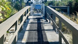 Un chemin menant à une entrée fermée par un portail, sur laquelle est apposée une pancarte indiquant qu’il s’agit d’une propriété privée.