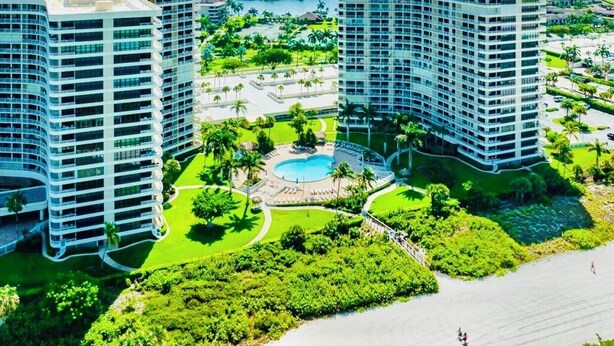 Un hôtel de grande hauteur, avec de nombreux étages, une cour intérieure dotée d’une piscine et entourée de verdure.