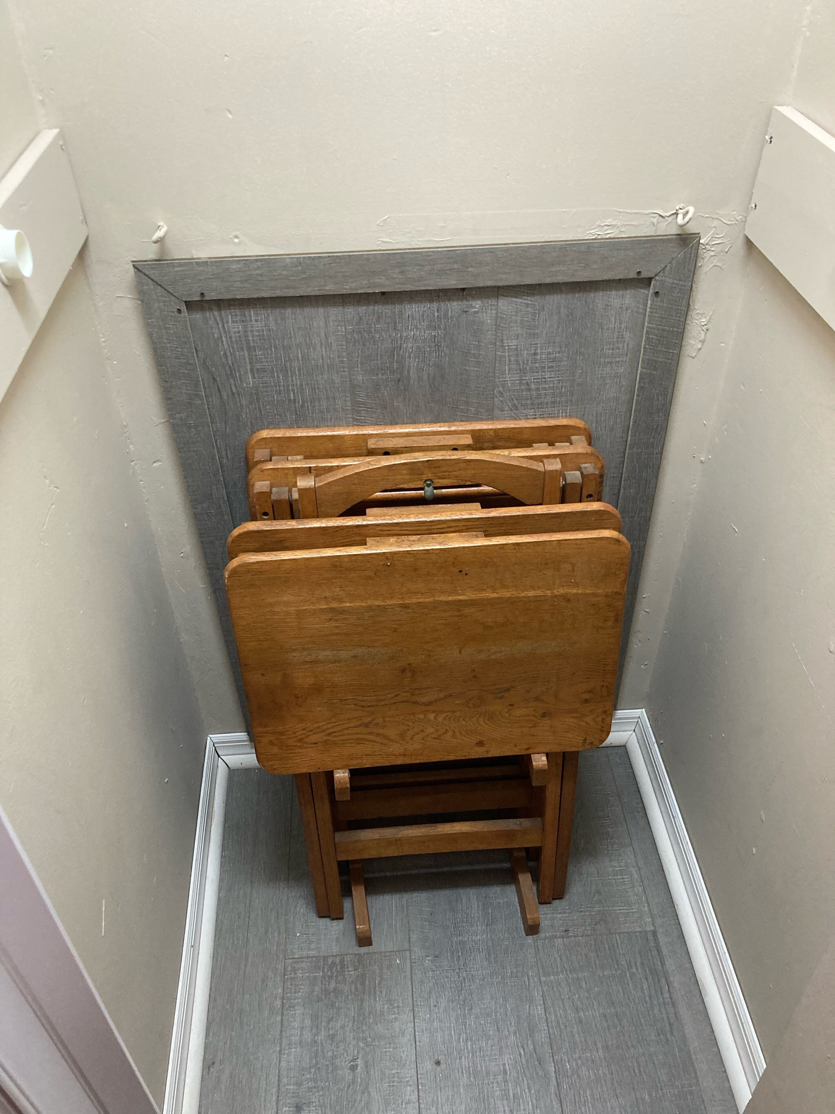 Un coin de pièce avec un banc en bois et un mur gris à la texture particulière.