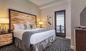 Relax in this inviting space with a large bed, bedside tables, and a TV on a wooden cabinet.