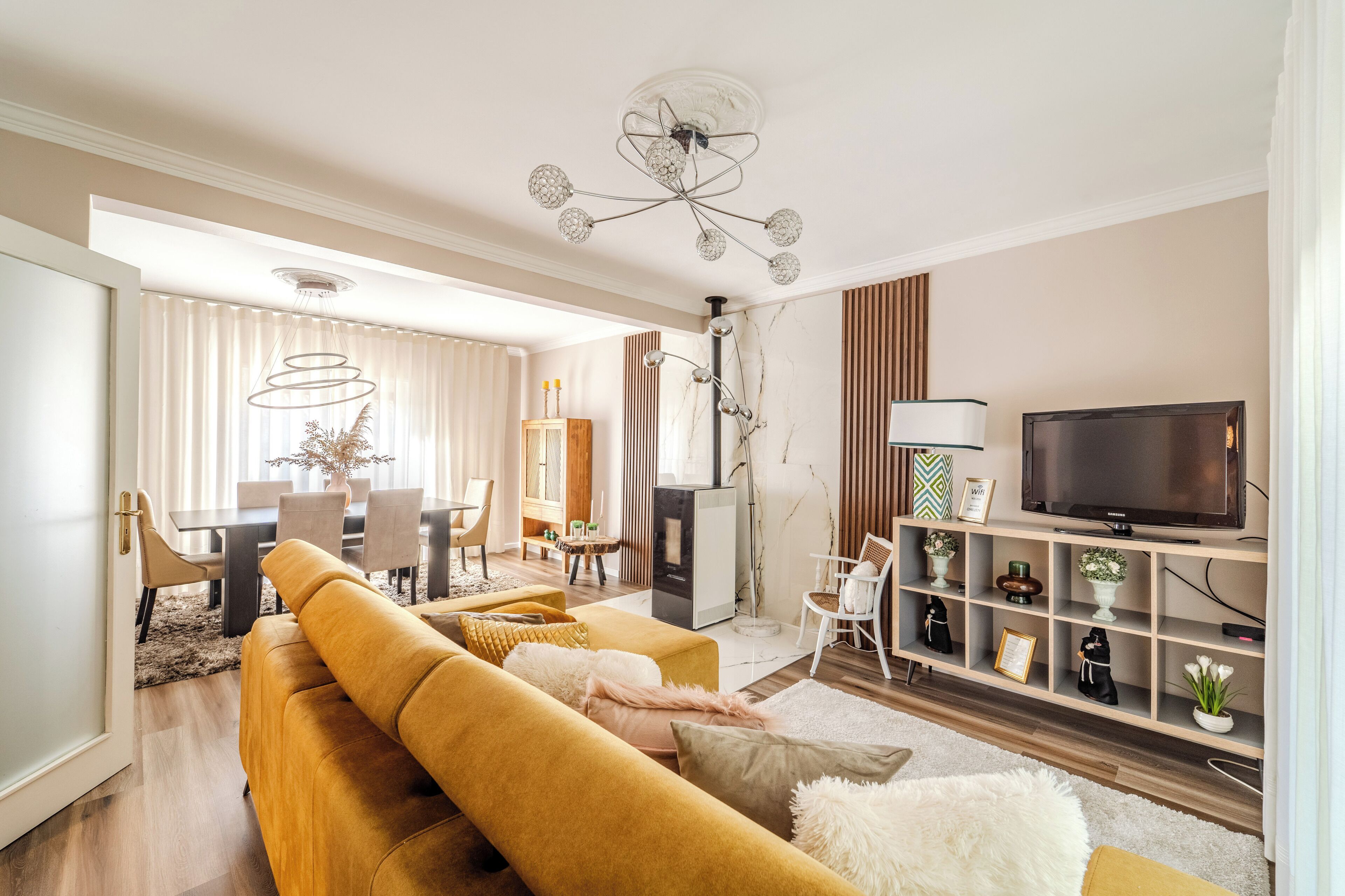 A modern living room with a sofa, TV, and decorative items.