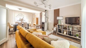 A modern living room with a sofa, TV, and decorative items.