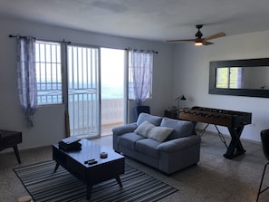 Relax in this stylish living room with a sofa, coffee table, and desk, plus a foosball table for entertainment.