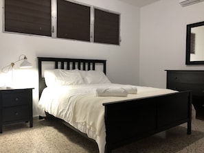 Cozy retreat with a single bed, bedside table, and dark dresser.
