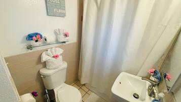 Een haardroger, handdoeken, shampoo, toiletpapier