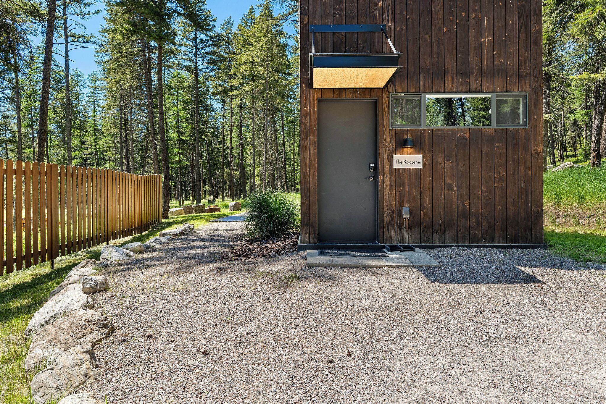 Une cabane en bois avec une porte, une petite fenêtre et une enseigne sur laquelle on peut lire «The Kootenay».