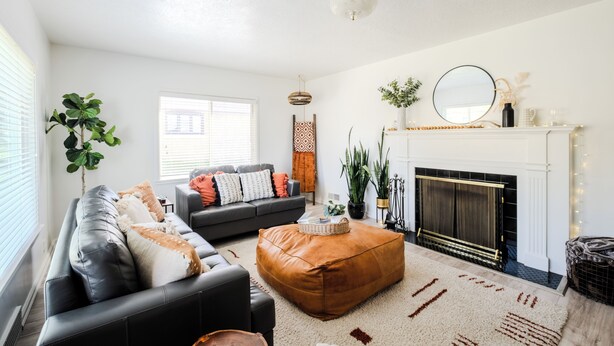 A living room with a fireplace, a sofa, a coffee table, and a potted plant. - The Cache Cottage ~ 5 BDR, 2.5 Bath SAUNA USU Logan Canyon SKITHEBEAV Bear Lake (Logan)