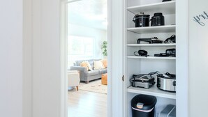 A kitchen with white shelving, a blender, a coffee maker, and a trash bin. - The Cache Cottage ~ 5 BDR, 2.5 Bath SAUNA USU Logan Canyon SKITHEBEAV Bear Lake (Logan)