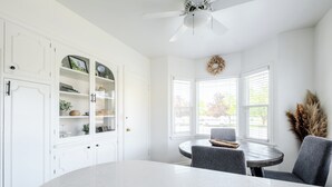 A modern kitchen with white cabinetry, a round dining table, and a ceiling fan. - The Cache Cottage ~ 5 BDR, 2.5 Bath SAUNA USU Logan Canyon SKITHEBEAV Bear Lake (Logan)