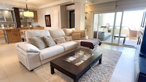 A modern living room with a sofa, coffee table, and a view to the outside. - Magnificent One Bedroom Apartment in Marbella Center. (Marbella)