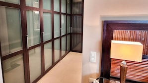 A hallway with frosted glass doors and a wooden bench with a lamp. - Magnificent One Bedroom Apartment in Marbella Center. (Marbella)