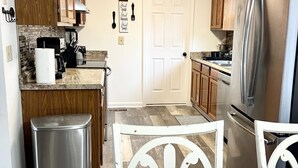 A kitchen with wooden cabinets, a stainless steel refrigerator, and a tiled backsplash. - 🏡 Cozy Home <5 Miles to Boat Ramp—Book Now! (Scottsboro)