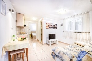 Cozy retreat with a kitchenette, television, and comfortable bed.