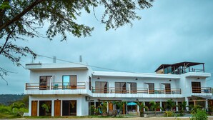 Un edificio de dos plantas con balcones y un porche.