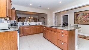 A spacious kitchen with wooden cabinets, a granite countertop, and a central island. - 3 BR, 2 Baths, Pets & family friendly, Historical safe home + 5 miles downtown (San Antonio)