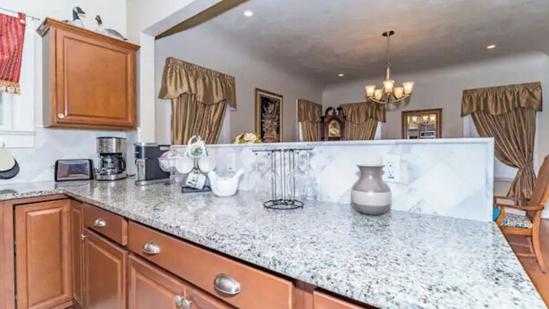 A kitchen with granite countertops, wooden cabinets, and a central island. - 3 BR, 2 Baths, Pets & family friendly, Historical safe home + 5 miles downtown (San Antonio)