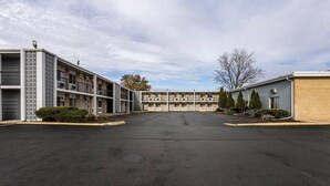 A motel with a central courtyard, multiple-story buildings, and a parking lot.