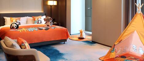 A hotel room with a bed, a sofa, a chair, a small table, a lamp, a window, and a tent.