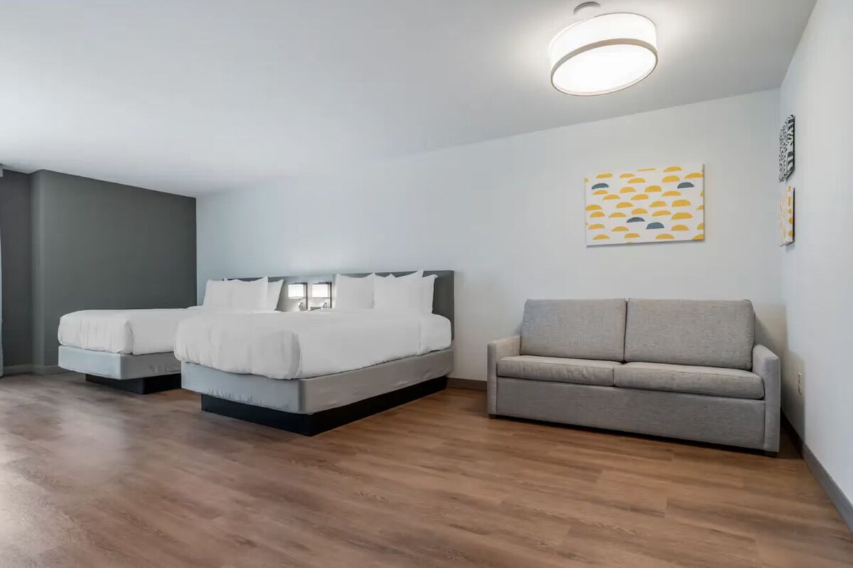 Un dormitorio con cama, sofá e iluminación en el techo.