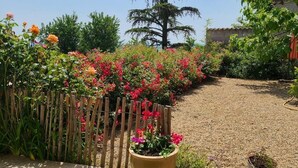 A garden pathway with a wooden fence and potted plants. - Les Vignes de Théonie (VILLIE-MORGON)