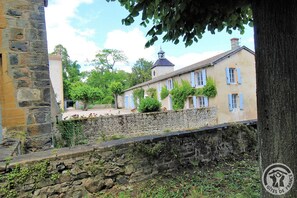 Un mur de pierre avec un bâtiment en pierre en arrière-plan.