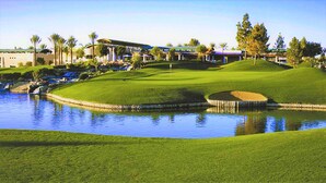 Un parcours de golf doté d’un étang, d’un club-house et d’un parking.