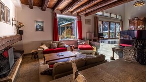 Un salon confortable avec une cheminée, un ensemble de canapés, une table basse et un téléviseur.