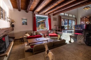 A cozy living room with a fireplace, a sofa set, a coffee table, and a TV.