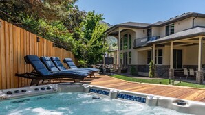 A backyard with a hot tub, lounge chairs, and a patio area. - Olympus Luxury-Prime Location- HotTub+Theater+More (Millcreek)