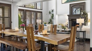 A spacious dining area with a long wooden table and matching chairs, a fireplace, and a cozy seating area with a sofa and side tables. - Olympus Luxury-Prime Location- HotTub+Theater+More (Millcreek)