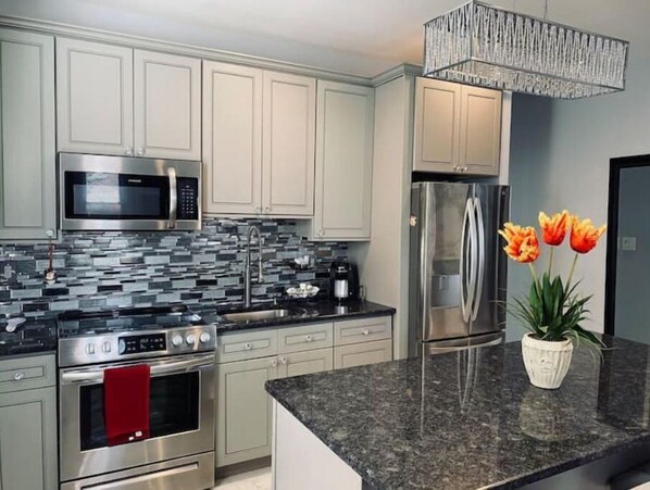 Enjoy cooking in this well-equipped kitchen with a sink, microwave, oven, and refrigerator.