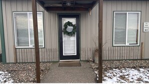 A building with a black door, a wreath, and a sign indicating 'The Shed Parking'. - Comfortable and cozy getaway in the heart of Crosslake (Crosslake)