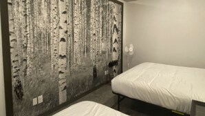 A hotel room with two single beds, a large wall mural of birch trees, a white ceiling, and a white wall. - Comfortable and cozy getaway in the heart of Crosslake (Crosslake)