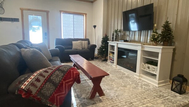 A living room with a fireplace, a television, and a Christmas tree. - Comfortable and cozy getaway in the heart of Crosslake (Crosslake)